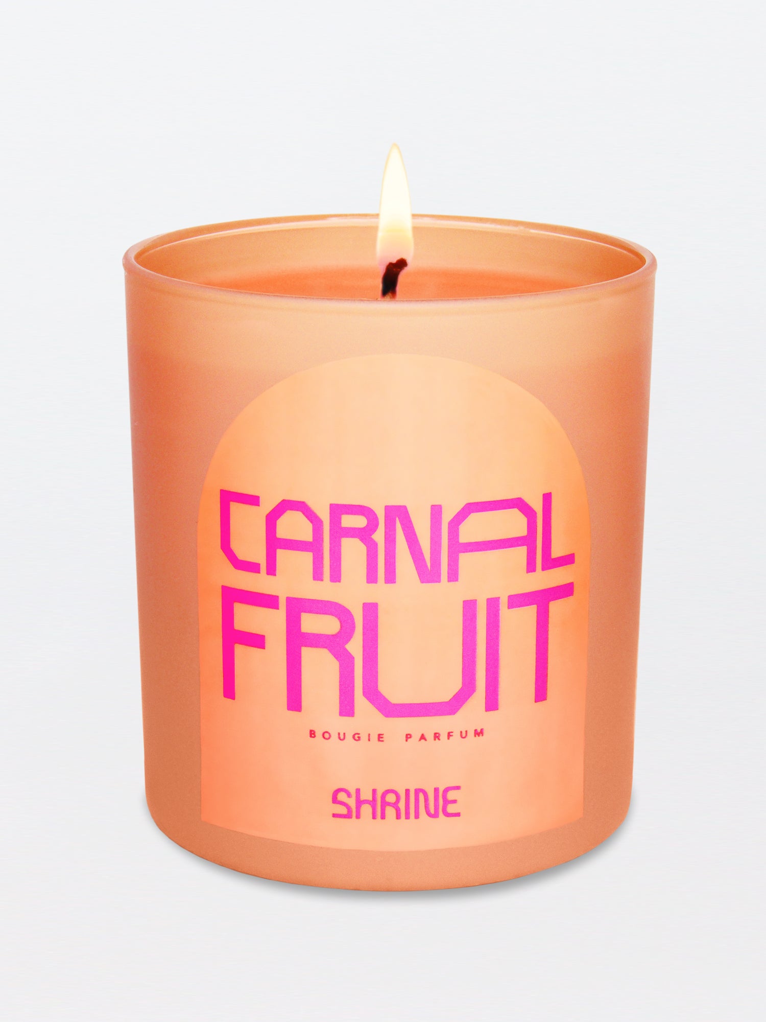 shrine carnal fruit monochromatic peach candle with neon pink text design in a neon pink logo label shop shrine shopshrine
