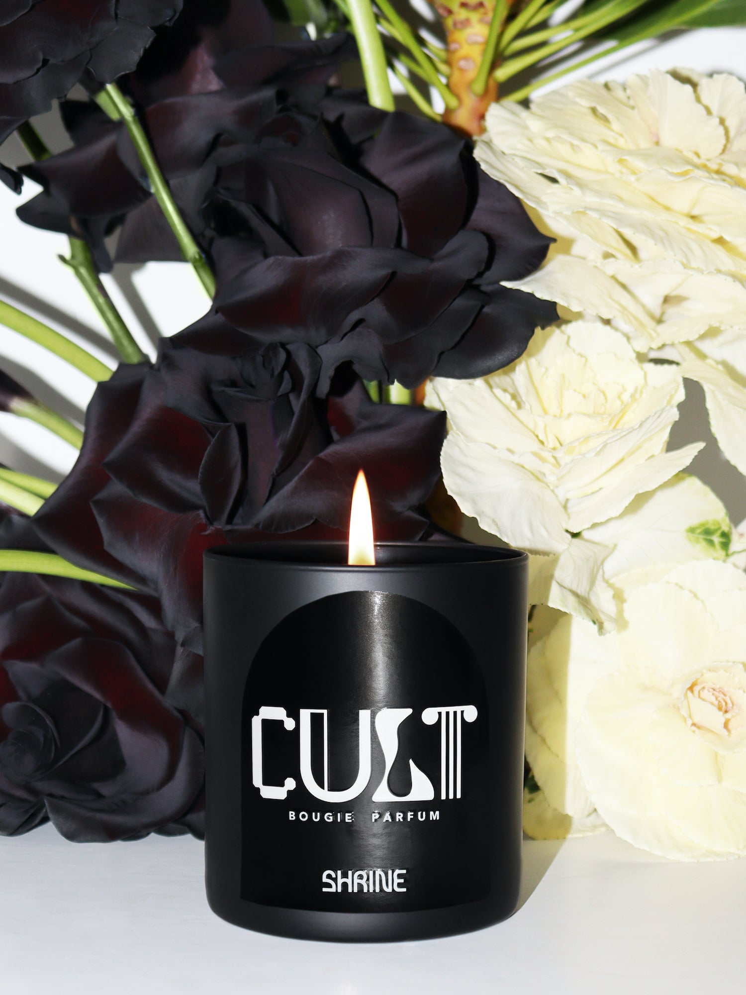 shrine shop shrine black monochromatic cult scented candle with white text design with black and white flower arrangement